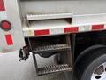 A side view of a grey 2011 Dodge Ram 5500 truck with a metal step ladder attached to the rear and visible taillights and reflectors