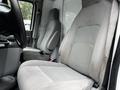 Interior of a 2013 Ford Econoline showing two gray fabric front seats with a simple dashboard and center console visible