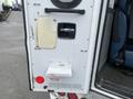 A white door of a 2016 Chevrolet Express with an emergency release label visible and a handle on the side for opening the door