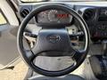 Steering wheel of a 2014 Hino 195 with dashboard gauges and controls visible in the background