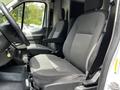 Interior view of a 2022 Ford Transit showing two black fabric bucket seats with armrests and a steering wheel in the foreground