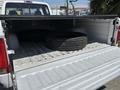 A 1995 Ford F-250 truck bed with two stacked tires inside