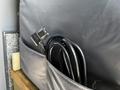 A black power cord with a connector is neatly stored in a pocket of a 2017 Mercedes-Benz Sprinter's interior panel