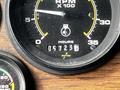 Close-up of a gauge showing RPM and hours for a 1991 Sutphen Deluge with numbers indicating 057230 for hours and corresponding RPM readings