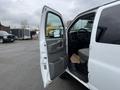 A 2012 Chevrolet Express van with its passenger door open revealing the interior and driver's seat