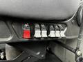 Close-up of a control panel featuring six toggle switches mounted on the side of a truck seat with one red switch and five white switches