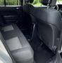 Interior of a 2013 Jeep Liberty Sport showing the back seat with fabric upholstery and a cup holder between the seatbacks