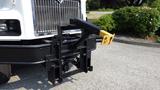 A front-mounted hydraulic frame with a yellow arm attached to a black base on a 2003 International 5600i truck