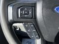 Close-up of a steering wheel with control buttons for navigating settings and adjusting cruise control on a 2018 Ford F-550