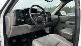 Interior of a 2013 Chevrolet Silverado 1500 with a steering wheel, dashboard controls, and two front seats