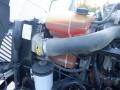 A close-up view of the engine compartment of a 2014 International Durastar showing the coolant reservoir and hoses connected to the engine