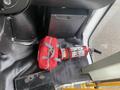 A red fire extinguisher and a red emergency kit are located on the floor of a Chevrolet Express vehicle