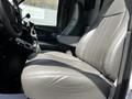 A gray leather driver's seat in a 2013 Chevrolet Express van, showing its upholstery and armrest without any visible wear or damage