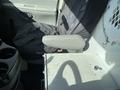 Interior of a 2008 Ford Econoline with a driver seat covered in fabric and an armrest along with a small table and cup holder area