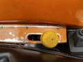 Close-up of a yellow control knob on an orange panel of a 2001 Agco ST40 tractor showing wear and metal trim around the control area