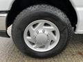Close-up of a silver wheel with a Good Year tire mounted on a 2009 Ford Econoline, displaying deep treads and a multi-spoke wheel design
