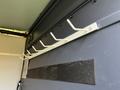 A 2017 Mercedes-Benz Sprinter interior showing a metal rack with white hooks mounted on the wall