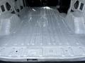 Interior view of a 2018 Ford Transit cargo van showing a clean and empty metal floor with raised ridges and flat surfaces