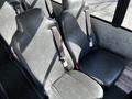 Two padded seats in dark gray leather with seatbelts, designed for a school bus interior, indicating seating arrangements in a 2022 Blue Bird Vision
