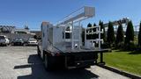 A 2019 RAM 3500 truck with a flatbed and a white utility box mounted on the rear featuring a ladder rack and tool storage compartments