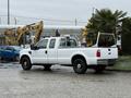A white 2008 Ford F-250 SD pickup truck with a crew cab and an open bed featuring a metal rack in the back