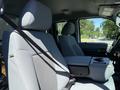 Interior view of a 2014 Ford F-250 SD with gray fabric seats and armrest showing seat belts and console