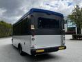 A 2019 Chevrolet Express shuttle bus with a gray and white exterior parked with its rear facing the viewer