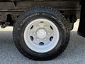 Close-up of a white wheel with a six-bolt pattern and a black all-terrain tire mounted on a 2007 GMC W3500