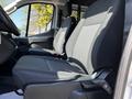 Two black fabric front seats of a 2023 Ford Transit facing forward with visible seat adjusters