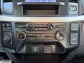 A dashboard console from a 2023 Ford F-550 featuring climate controls and infotainment system with various buttons and knobs