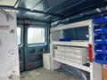 A blue 2010 Ford Econoline interior featuring shelves with storage bins and drawers organized for tools and equipment
