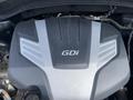 Close-up of the engine cover of a 2015 Kia Sorento featuring the GDi emblem on a sleek black and silver design