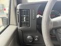 A close-up of the dashboard of a 2020 Chevrolet Express showing air conditioning controls and a steering wheel with various buttons