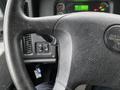 Close-up of a Freightliner 114SD steering wheel with controls and dashboard indicators visible in the background