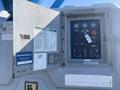 Control panel of a 1997 Genie S-65 4X4 featuring gauges switches and a notice label