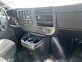 Interior view of a 2016 GMC Savana featuring a dashboard with controls a stereo system and cup holders
