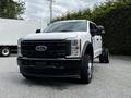 A 2024 Ford F-550 truck with a white exterior and black grille parked in a lot
