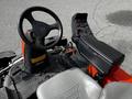 A close-up view of the steering wheel and control panel of a 2015 Jacobsen Eclipse with a gray seat and various controls and indicators visible on the panel