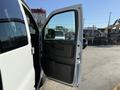 A 2021 Chevrolet Express van with its driver's side door open, showcasing the interior door panel and handle