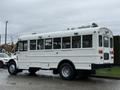 A 2016 International CE300 school bus painted white with multiple windows and lights on the roof positioned at an angle to the viewer