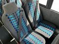 Interior seating of a 2022 Blue Bird BB Conventional bus featuring gray fabric with blue and turquoise patterns and safety seat belts