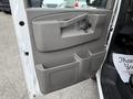 The interior door panel of a 2018 GMC Savana featuring a gray finish with a handle storage compartment and additional storage space near the bottom