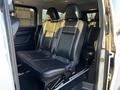 A 2022 Mercedes-Benz Metris interior featuring black leather seats arranged in two rows with seatbelts visible