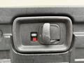 Close-up of the door latch on a 2009 Chevrolet Express showing a black handle and a red indicator button