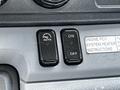 Two black buttons labeled AUTO and ON/OFF on a vehicle dashboard with a printed instruction label nearby.