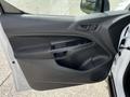The interior door panel of a 2016 Ford Transit Connect featuring armrest controls and a handle