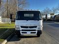 A 2014 Mitsubishi Fuso FE truck is parked facing forward with orange lights on the roof and a flat front design