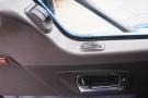 Interior door panel of a 2015 Kenworth T660 featuring controls for windows and door lock with a chrome handle