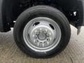 A close-up view of a 2015 Ford F-550 wheel featuring a silver rim with six bolt holes and a black tire with tread displayed