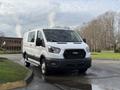 White 2023 Ford Transit van parked on a street with a black grille and silver wheels